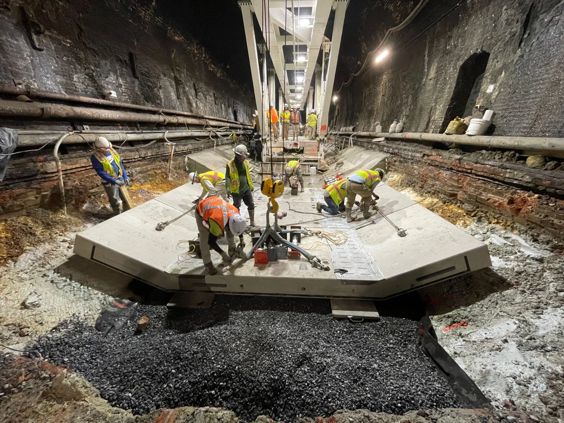 crew working with construction equipment inside tunnel