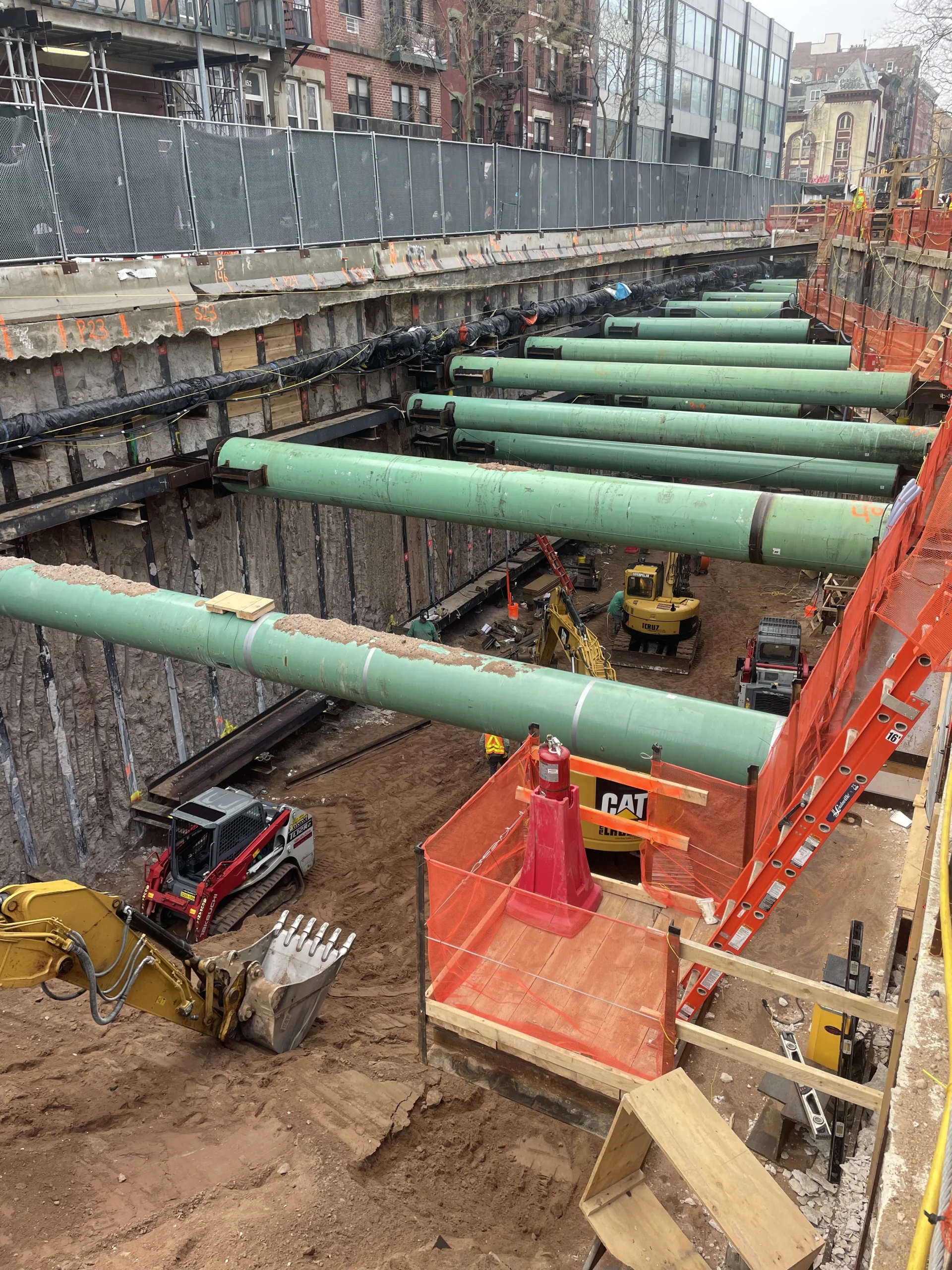 construction site with large vehicles and green pipes