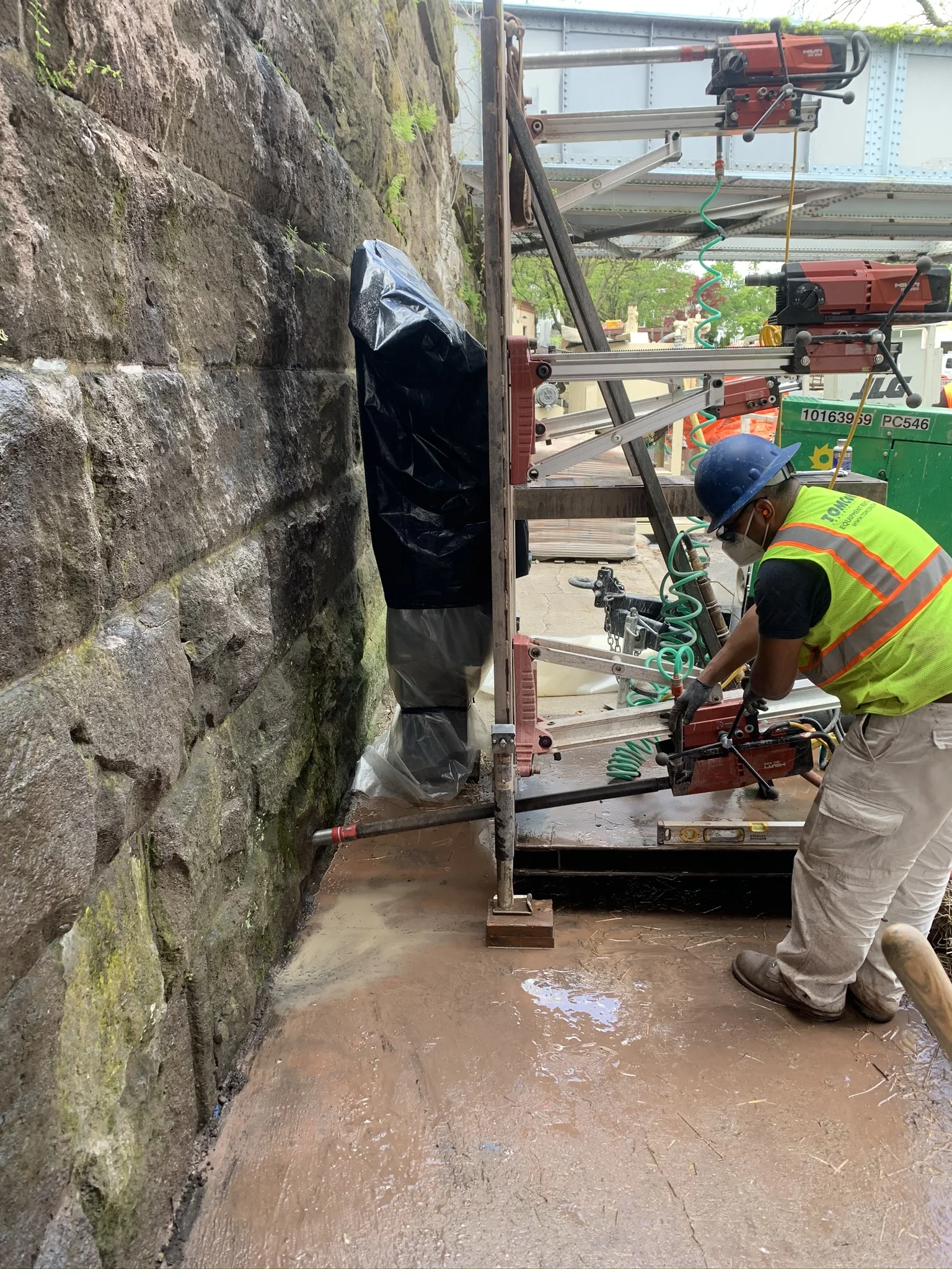 construction workers using equipment to work on stone bridge support