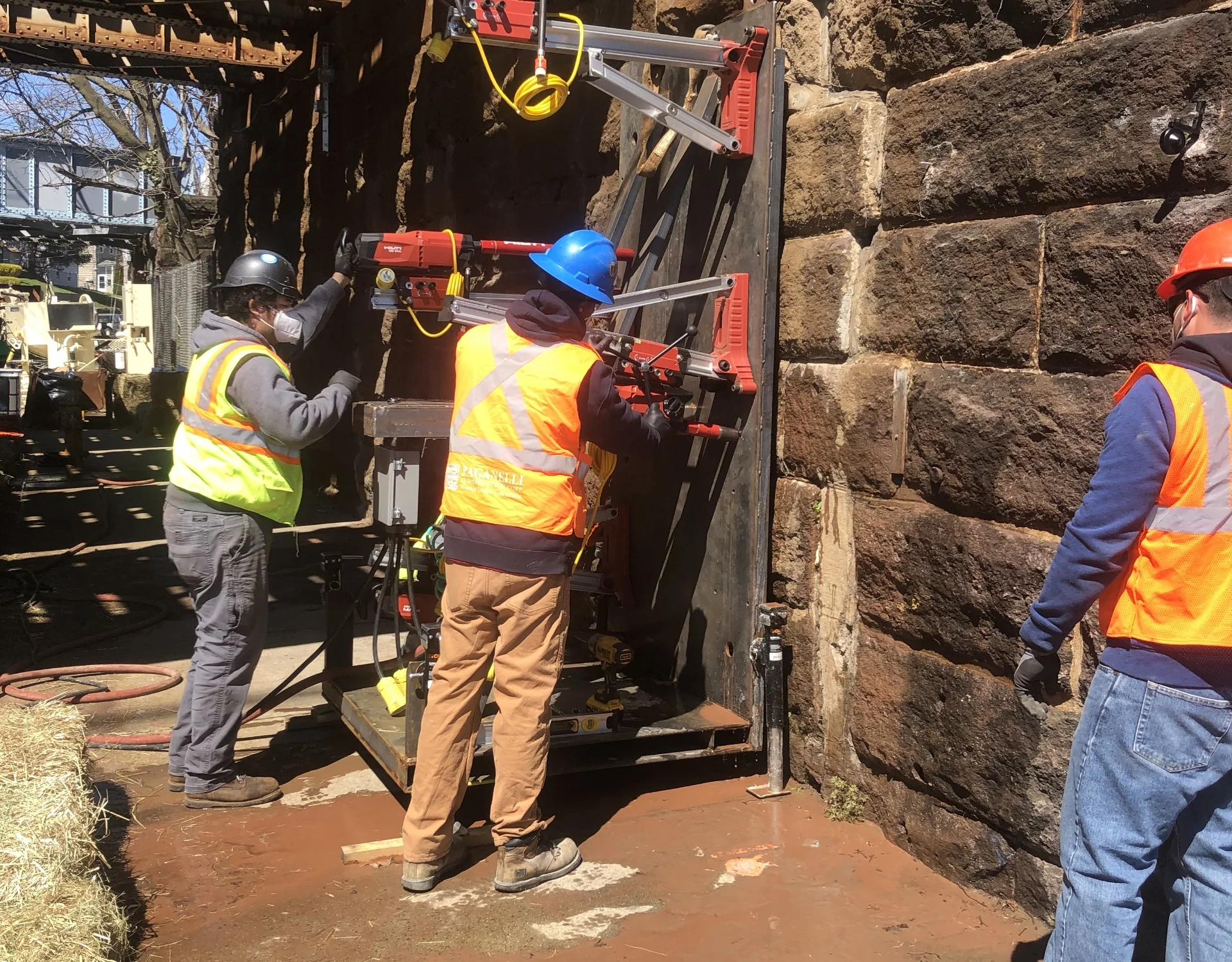 construction workers using equipment to work on stone bridge support